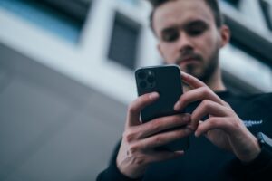 Mies pelaa nettikasinolla puhelimellaan